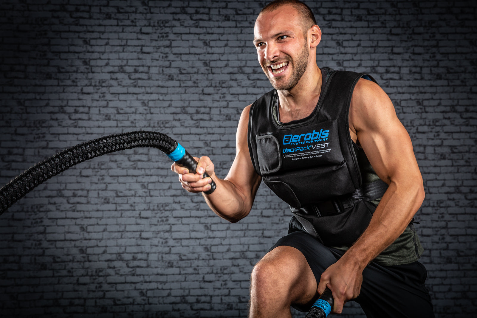 Athlete performing battle rope waves with an aerobis battle rope during a high-intensity EMOM conditioning workout