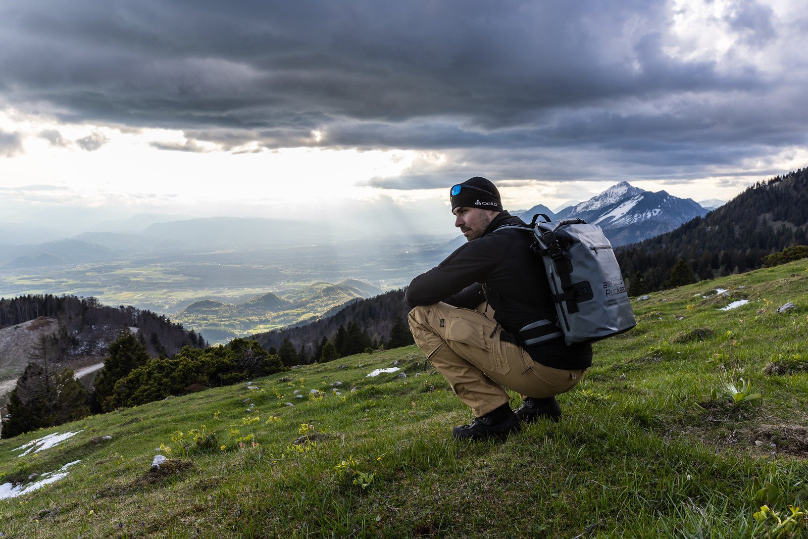 Man resting on a mountain ridge with a loaded aerobis Fitness Rucksack during a rucking session