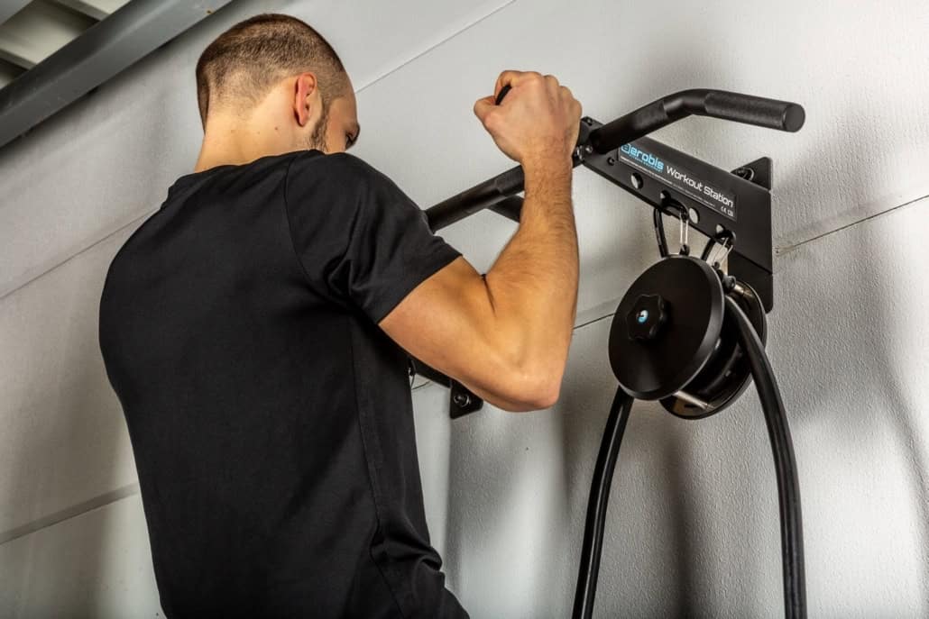 Man doing pull-ups on an aerobis workout station.