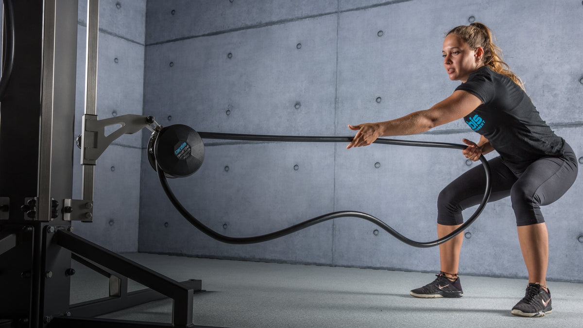 Woman training with the revvll ONE rope trainer indoors