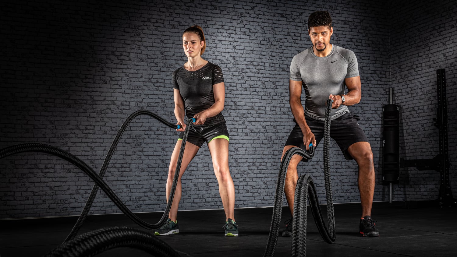 Zwei Athleten trainieren mit Battle Ropes