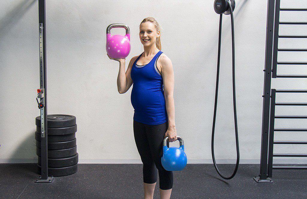 Introducción para una mujer que levanta kettlebells en un gimnasio.